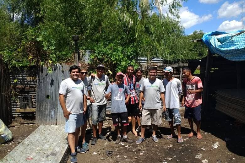 Hombres reunidos frente a una cerca, capturando un momento de encuentro y diálogo en un entorno natural.
